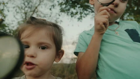 Children learning and exploring the nature with magnifying glasses. Curious Stock Footage 252657565