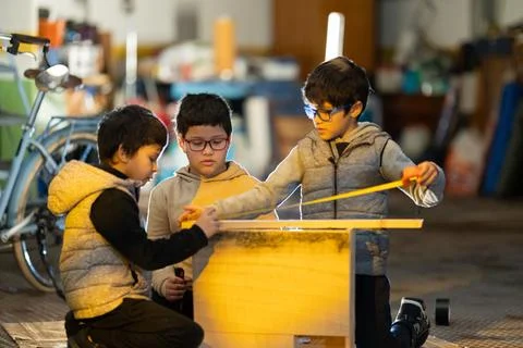 Children learning engineering skills building wooden project together Foto stock
