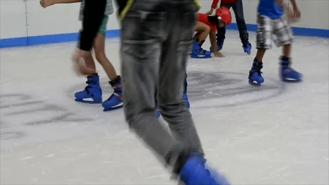 Children learning how to ice skate in a recreation hall Stock Footage