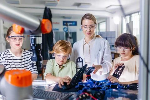 Children learning robotics in Elementary school. Young students building robot Foto stock