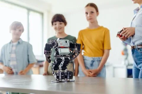 Children learning robotics in Elementary school, looking at small robot on desk 写真素材