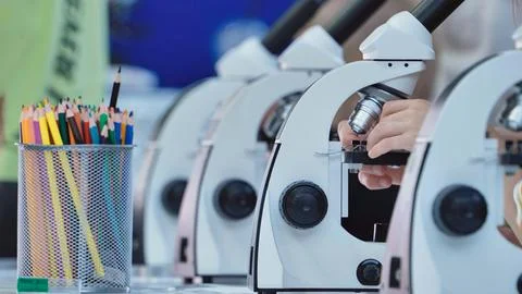 Children learning science concepts through hands-on microscope experiments in a 写真素材