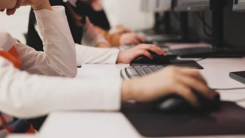 Children learning to use computer. Close up view of many hands on PC mouse. goes Stock Footage 232672139