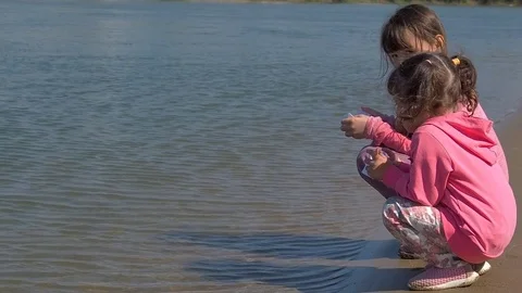 Children let the boats go. Little girls at the river with paper boats. Stock Footage