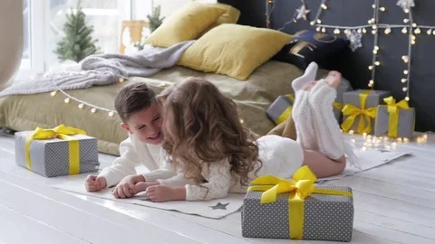 The children lie on the background of the Christmas interior. boy and girl next Video stock 85132817