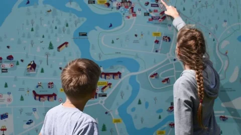 Children look at a road map and look for a place. city orientation Stock Footage 131910347