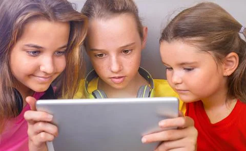 Children  look at the same tablet together Stock Photos