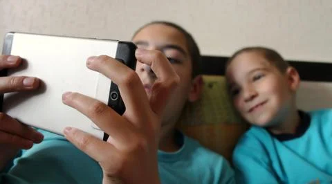 Children look at the screen of the tablet. Stock Photos