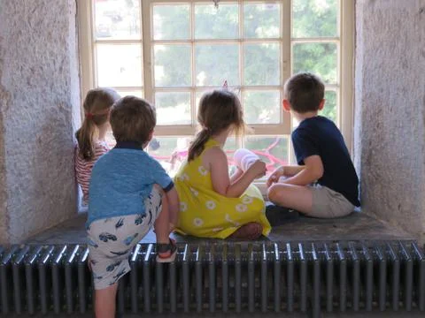 Children looking out a window Stock Photos