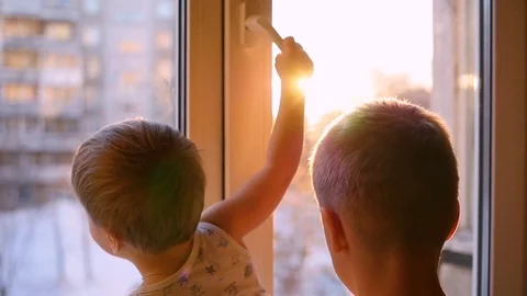 A children looks out the window through the sun in slowmotion 動画素材 73547607