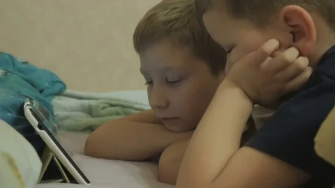 Children lying on a bed and watching the show Stock Footage 75875048