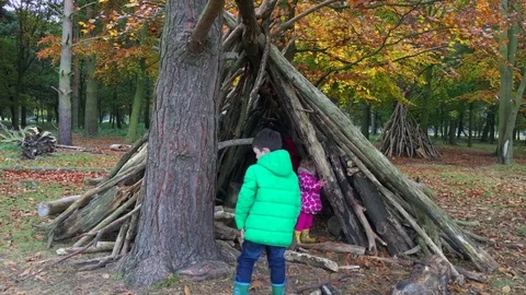 Children making a den out of branches in outdoor play area Stock Footage 76557869