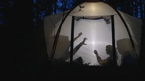 Children making shadow puppets in a camping tent at night Stock-Footage 282595893