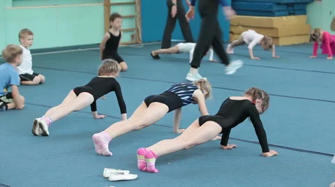 Children making shoulder dips on acrobatic lessons on the floor Stock Footage 39981000