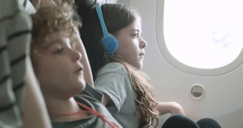 Children making themselves comfortable in a plane seat Video stock 107729151