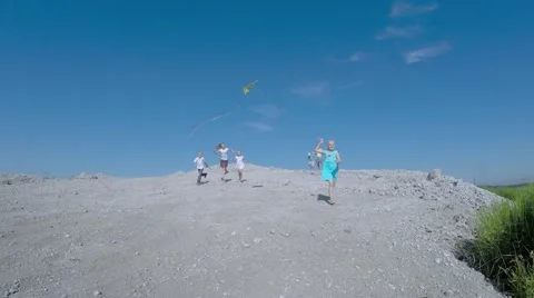 Children from the mountain run with a kite. Stock-Footage 53466536