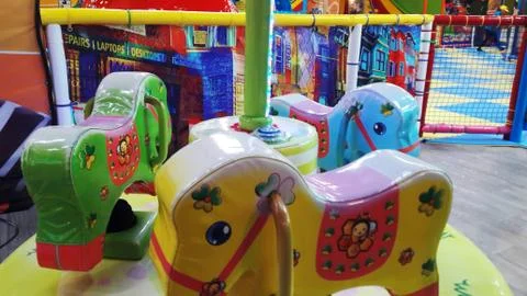 Children multi colored carousel in the form of horses Stock Photos