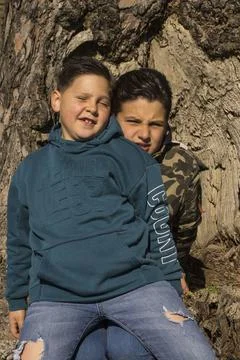 Children next to a tree trunk. 库存照片
