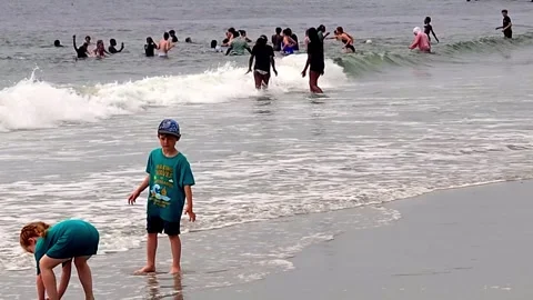 Children in the ocean at the beach having fun Stock Footage 337442260