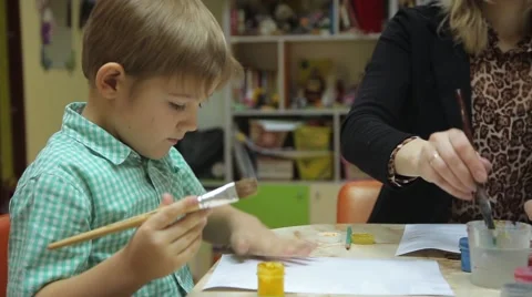 Children paint with brush on paper Stock Footage 59589134