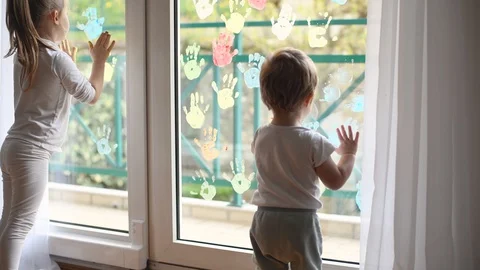 Children paint with palms on the window. Quarantine Stock Footage 129086689