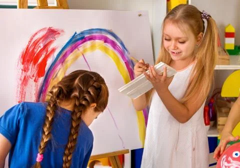 Children painting finger on easel. Group of kids with teacher. Stock Photos
