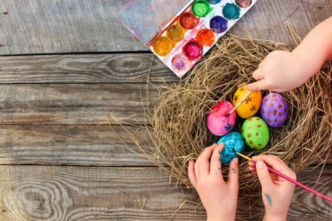 Children paints Easter eggs. Stock Photos