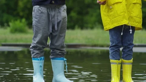 Children with Paper Boats Standing in Puddle Stock Footage