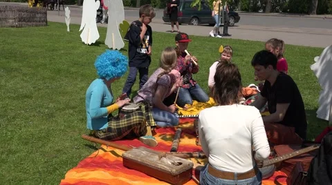 Children perform with various instruments on grass. 4K Stock Footage 53318523