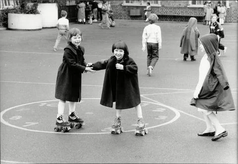 Children At Play 1980's - Children Roller Skating In The Playground At Brecknock Stock Photos