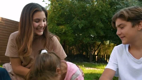 Children play and laugh while sitting on the grass. Happy family. Stock Footage 142500067