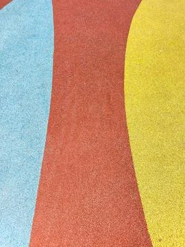 Children play on a bright rubber surface with blue, red, and yellow sections  Stock-Fotos