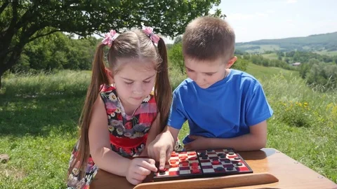 Children play checkers in the nature Stock Footage