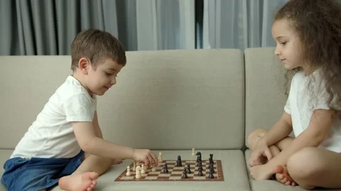 Children play chess while sitting on the devan at home, the development of Stock Footage 154387252