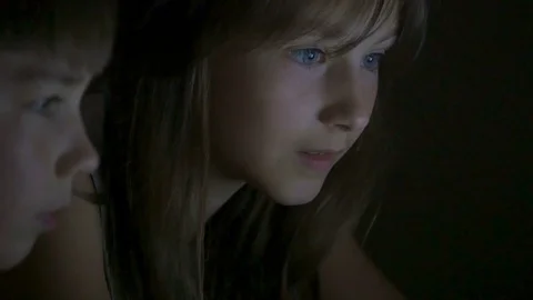 Children play on the computer in the bed under the blanket at night. Video stock 77172273