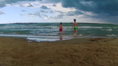 Children play on the deserted beach due to bad weather. Stock Footage 250104030