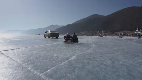 The children play on the ice on an inflatable ring. Rubber ring Stock Footage 104814761