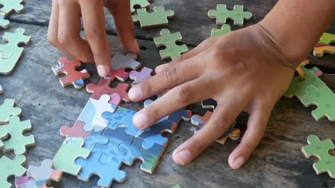 Children play jigsaw puzzles on the table. Stock Footage 310123382