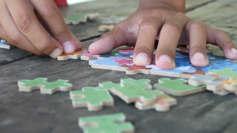 Children play jigsaw puzzles on the table. Stock Footage 310123403