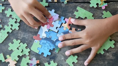 Children play jigsaw puzzles on the table. Stock Footage 310123508