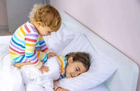 Children play jumping in bed. Selective focus. Stock Photos