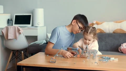 Children play with a metal constructor at the table at home. Stock Footage 239373786