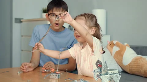Children play with a metal constructor at the table at home. Stock Footage 239374589