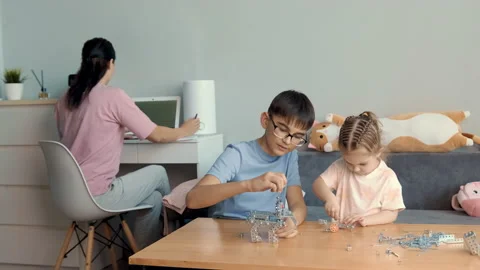 Children play with a metal constructor at the table at home. Stock Footage 239374685
