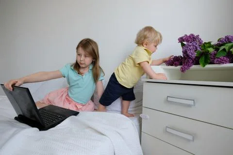 Children play in parents bed in laptop Stock Photos
