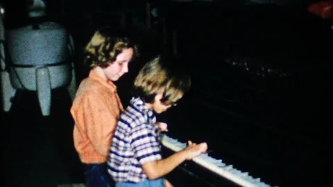 Children play piano for mom and dad at home 1950s vintage film home movie 4743 Stock Footage