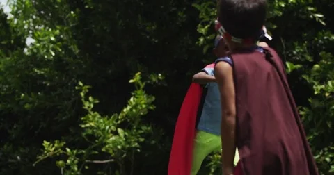 Children play pretend while dressed up as superheroes. Slow motion. Stock Footage 69190391