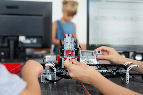 Children play with a robot in a robotics class. Stock Photos