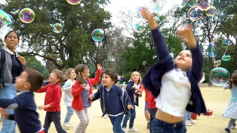 Children play with soap bubbles in Parc de la Ciutadella Stock Footage 90062417