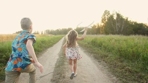 Children playing with airplane at sunset Stock Footage 82204142